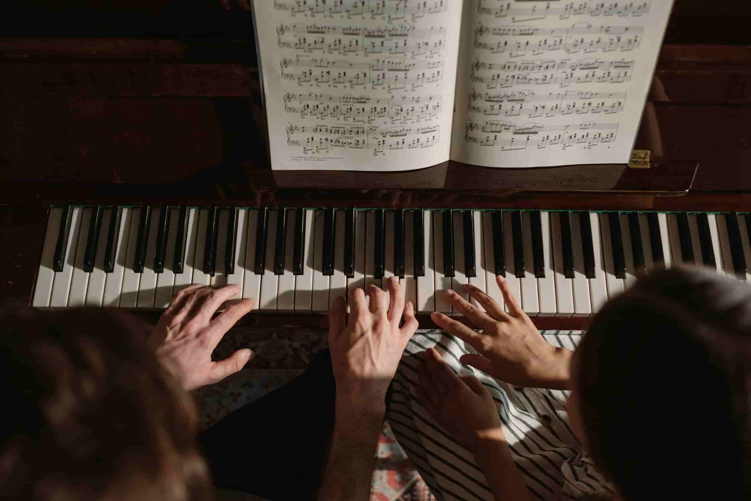 Birds eye shot of a woman taking piano lessons