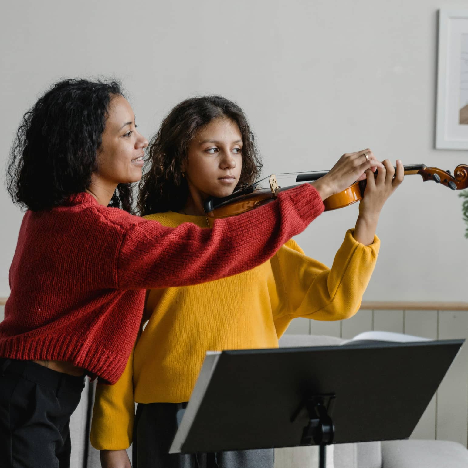 Violin teacher helping student in violin lessons