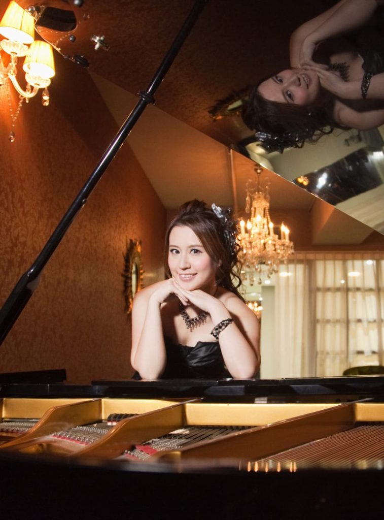 Fiona Wong standing over a piano
