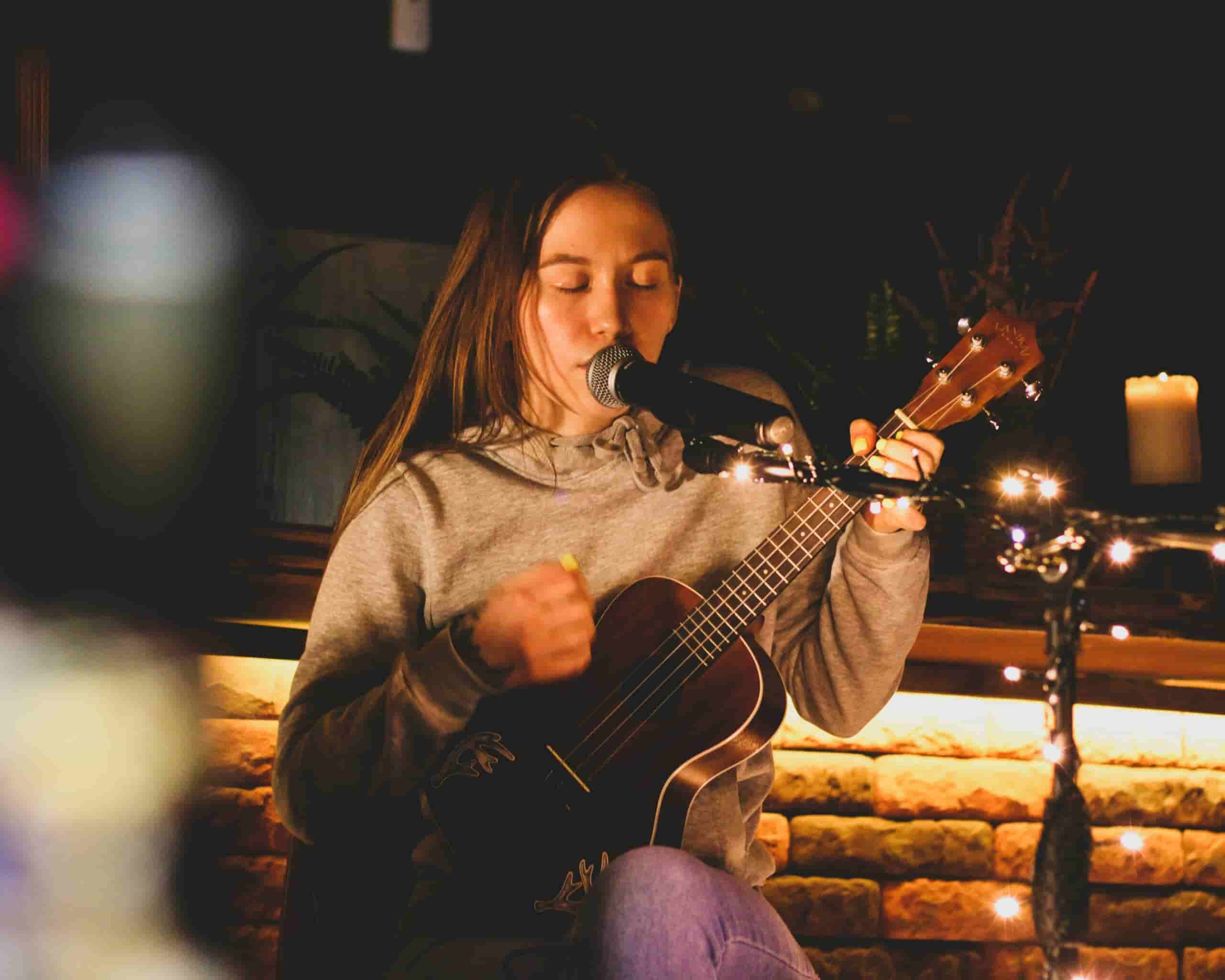 A girl singing and playing the ukulele