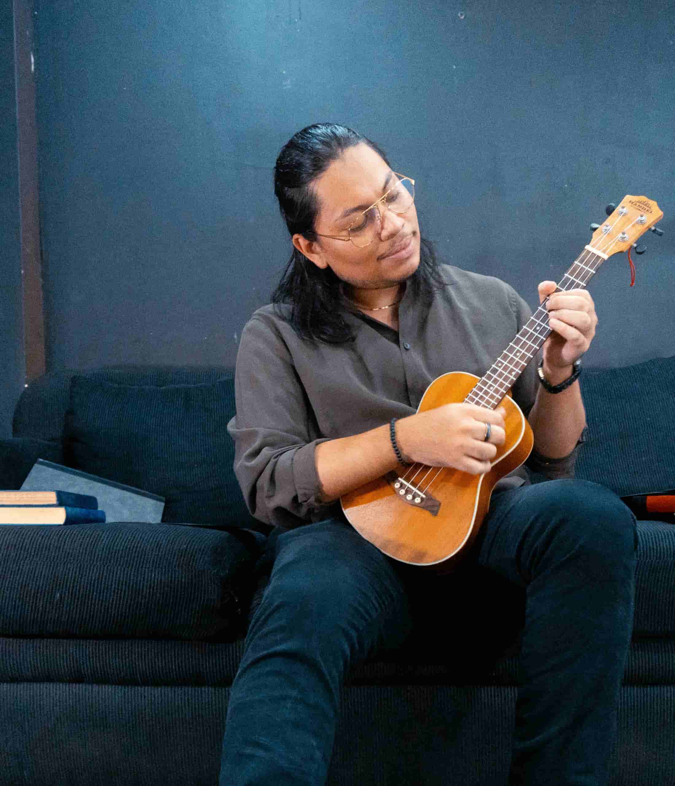 A ukulele teacher holding a ukulele