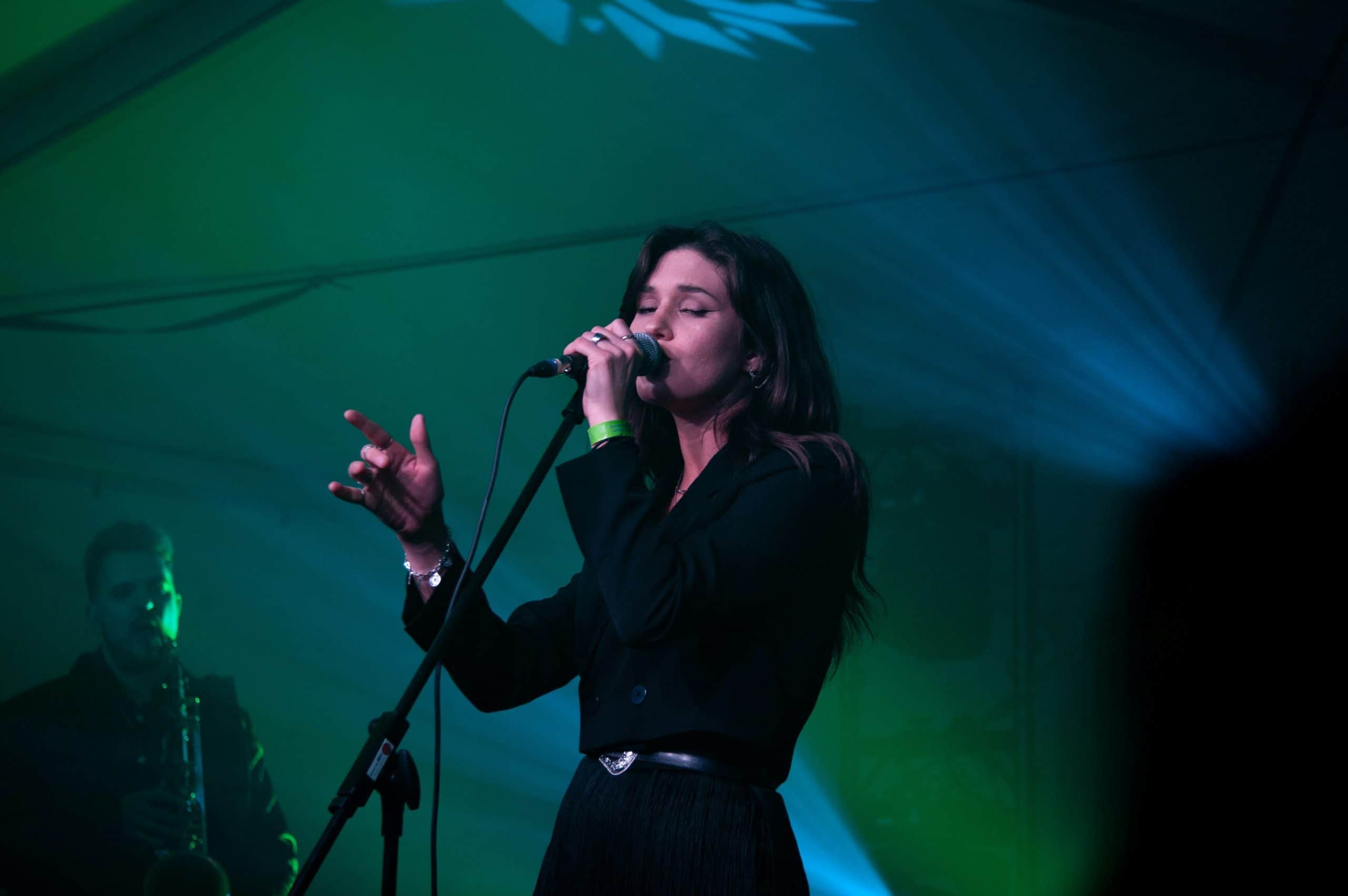 Landscape image of woman singing in black clothes