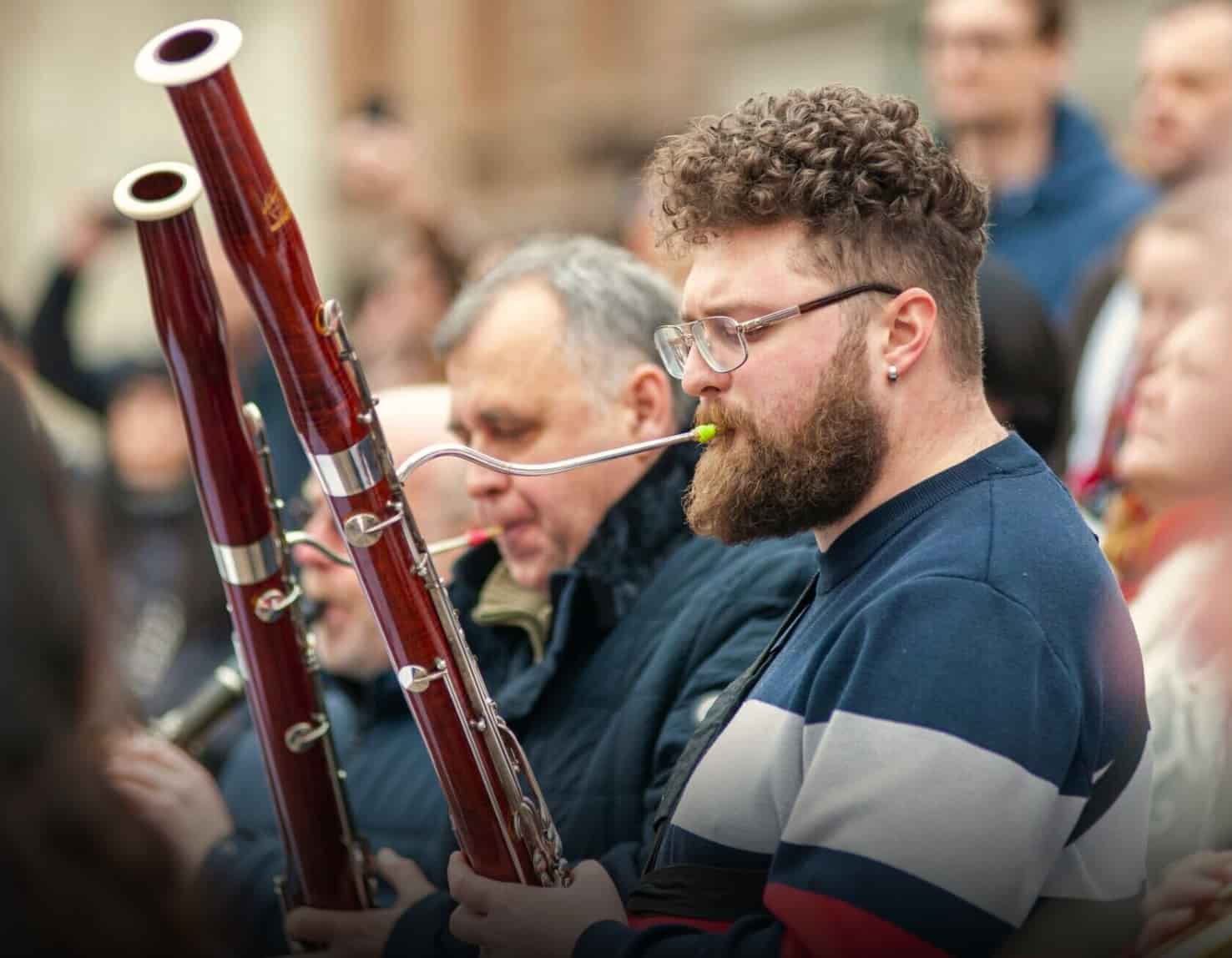 Two men playing bassoon in orchestra