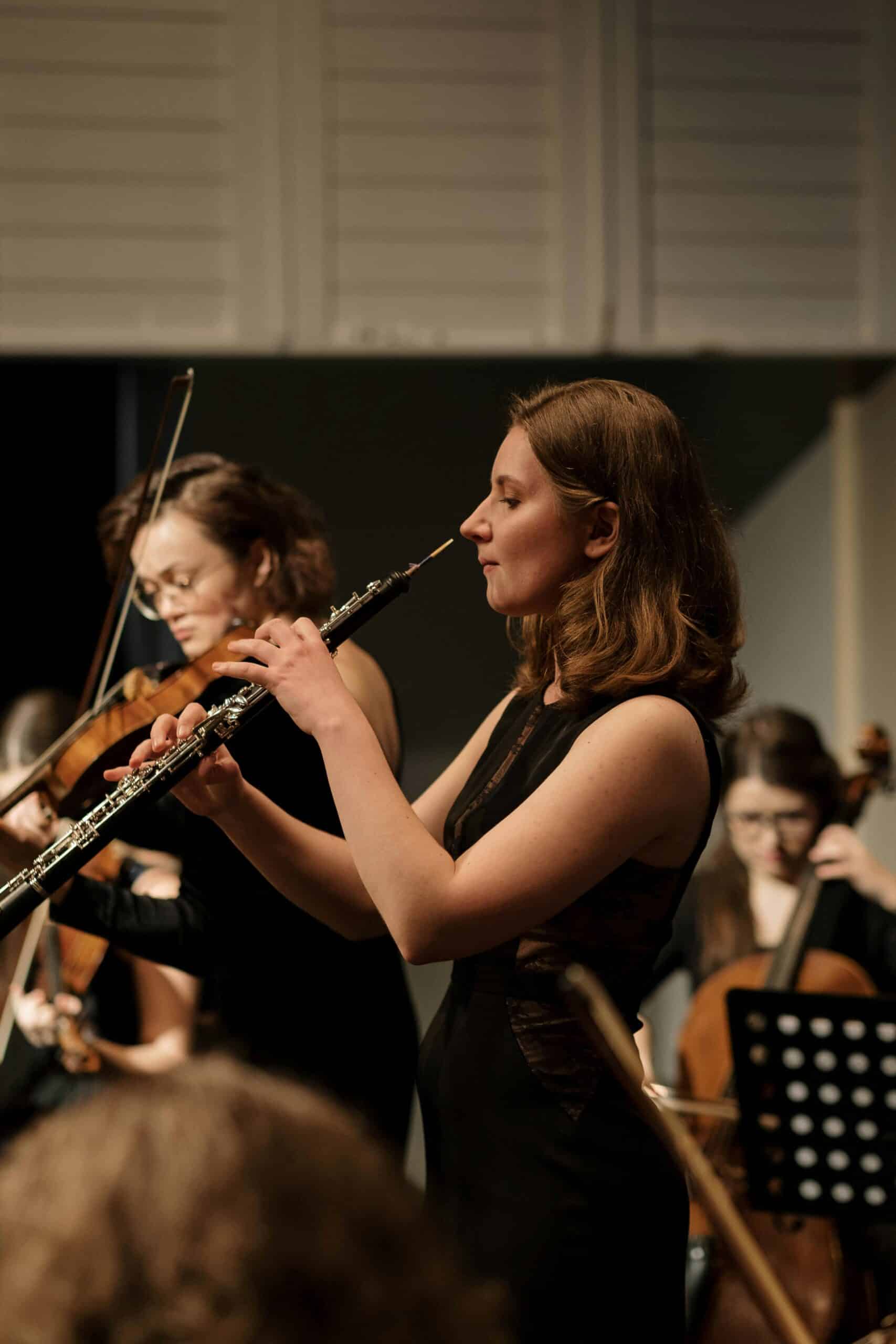 Woman playing oboe in orchestra