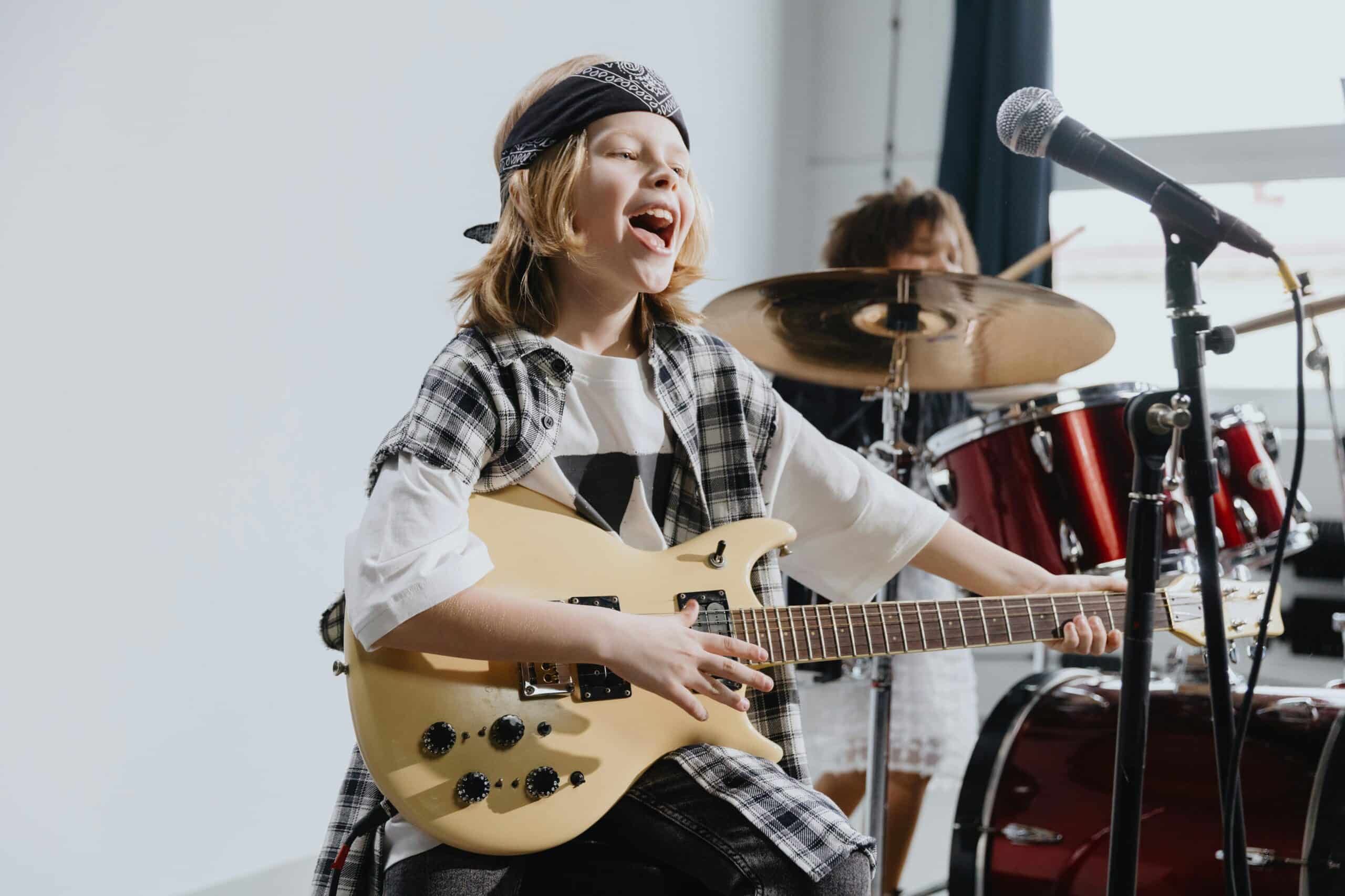 Boy playing electric guitar and singing