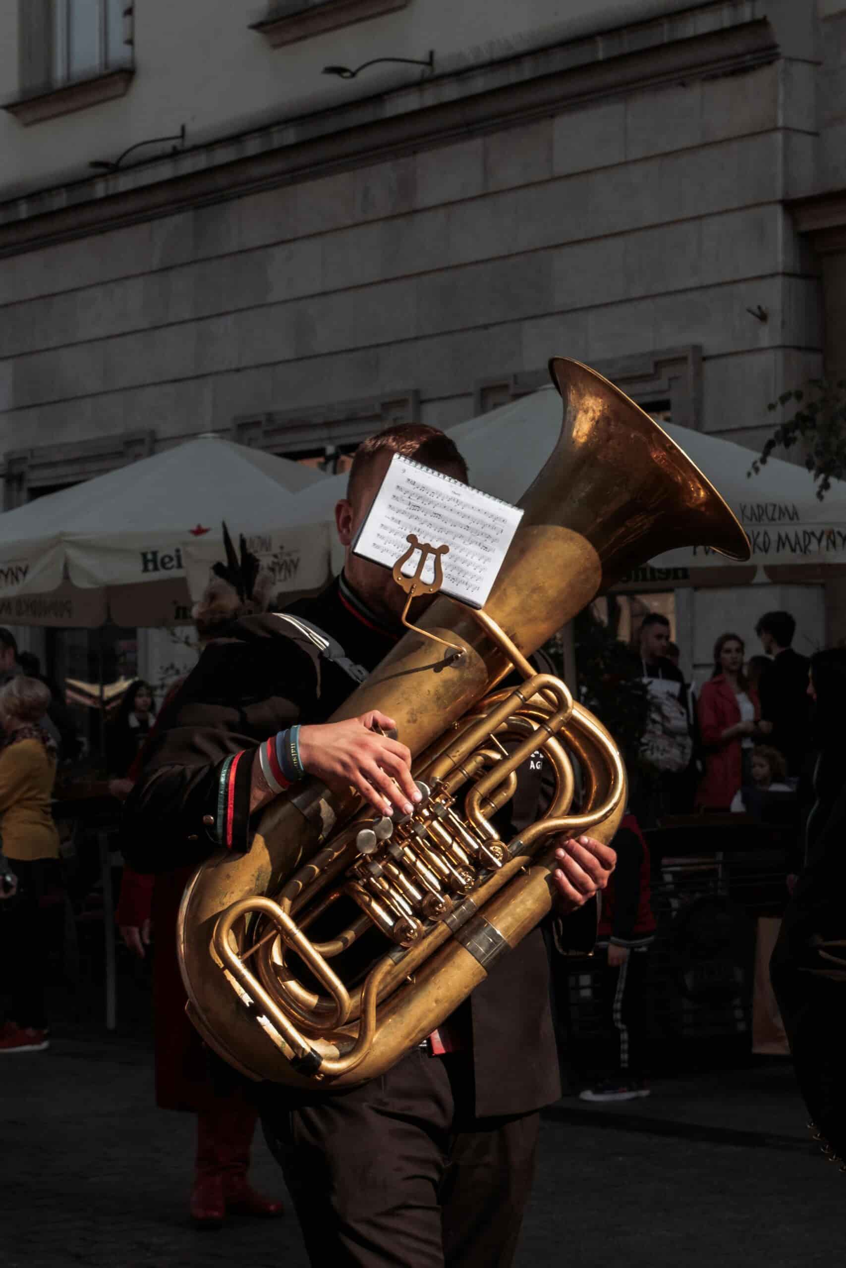 Man playing tuba with notes attached to the tuba