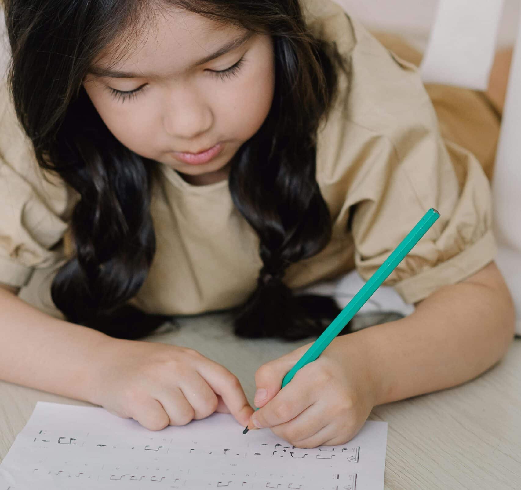Girl taking music composition lessons writing on page
