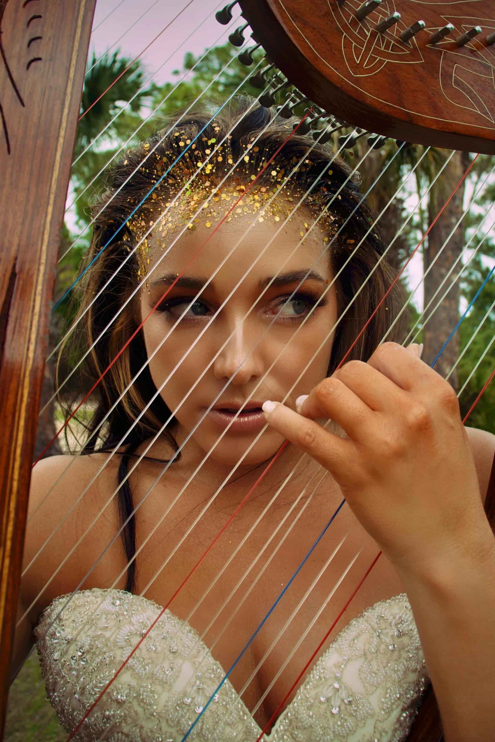 Woman playing the harp in white dress