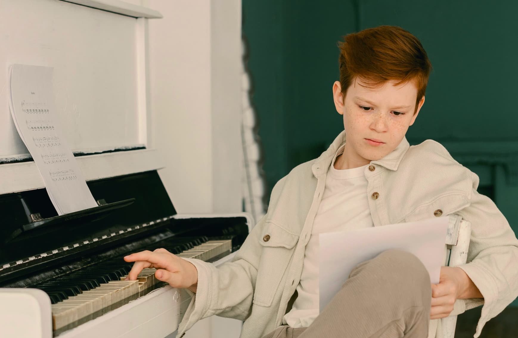 Boy during piano lessons looking at his notes