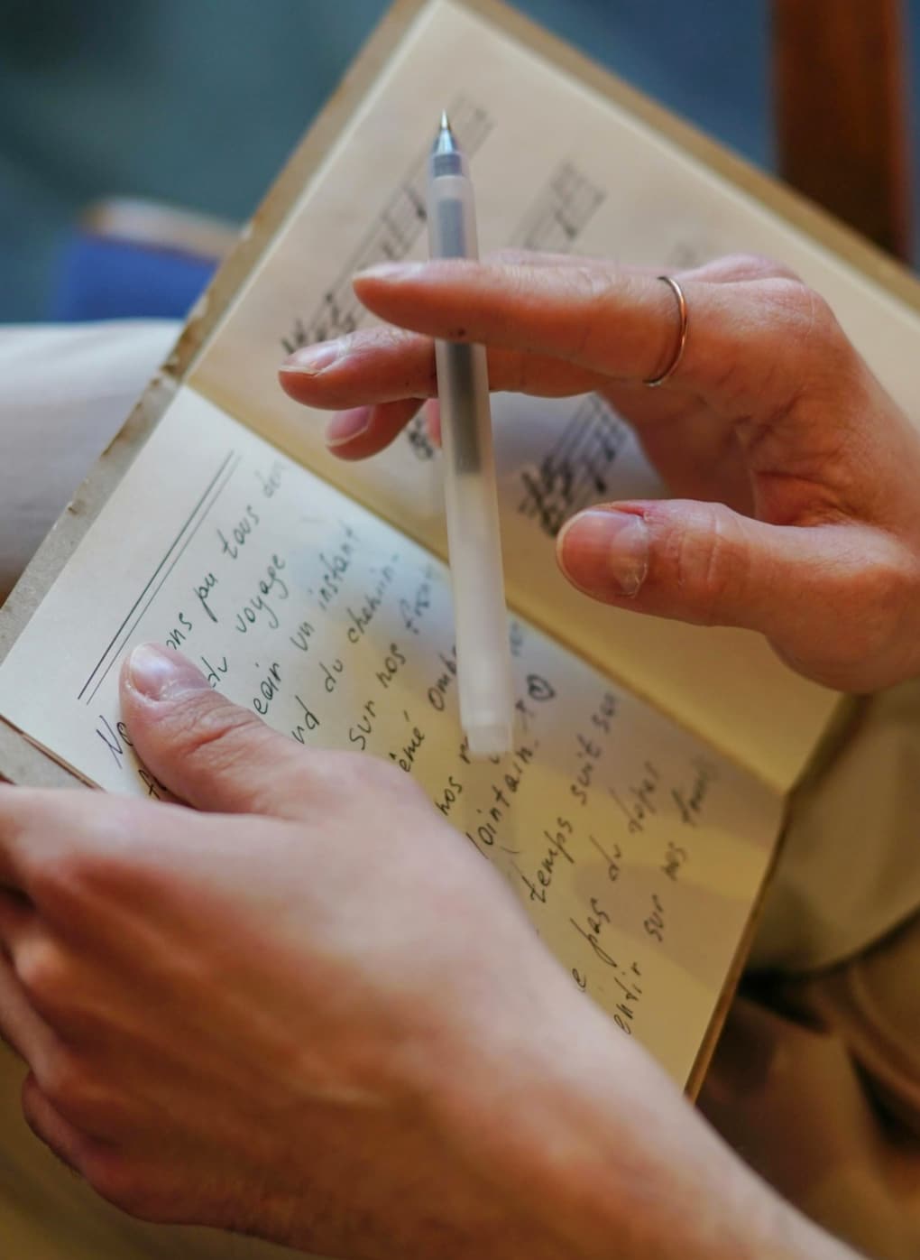 Close up of adult student songwriting in a book