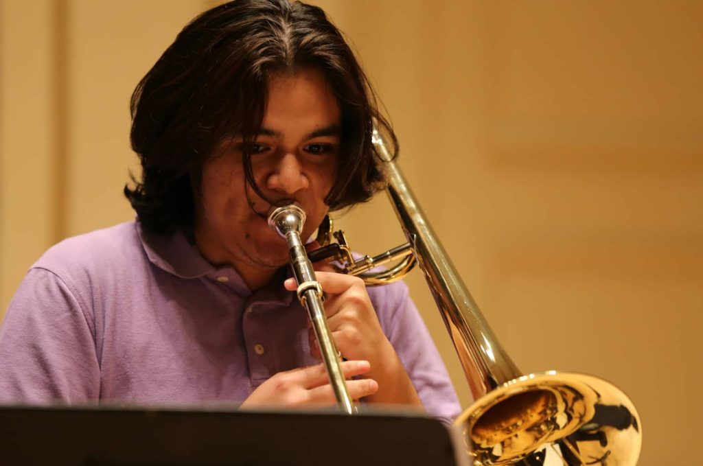 Man playing trombone in trombone lessons