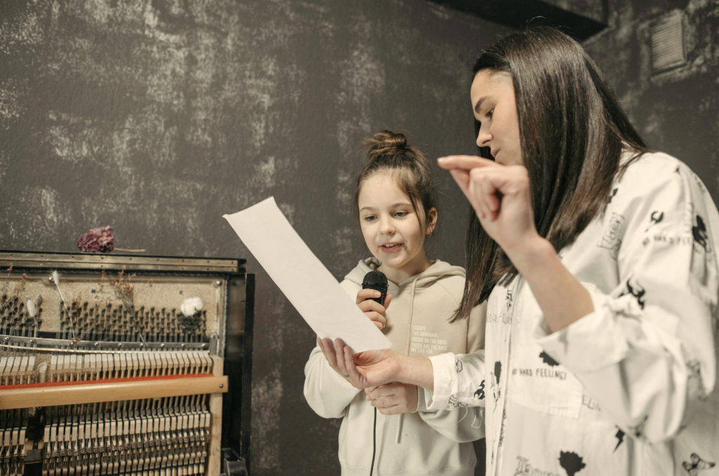 Girl in singing lessons with singing teacher