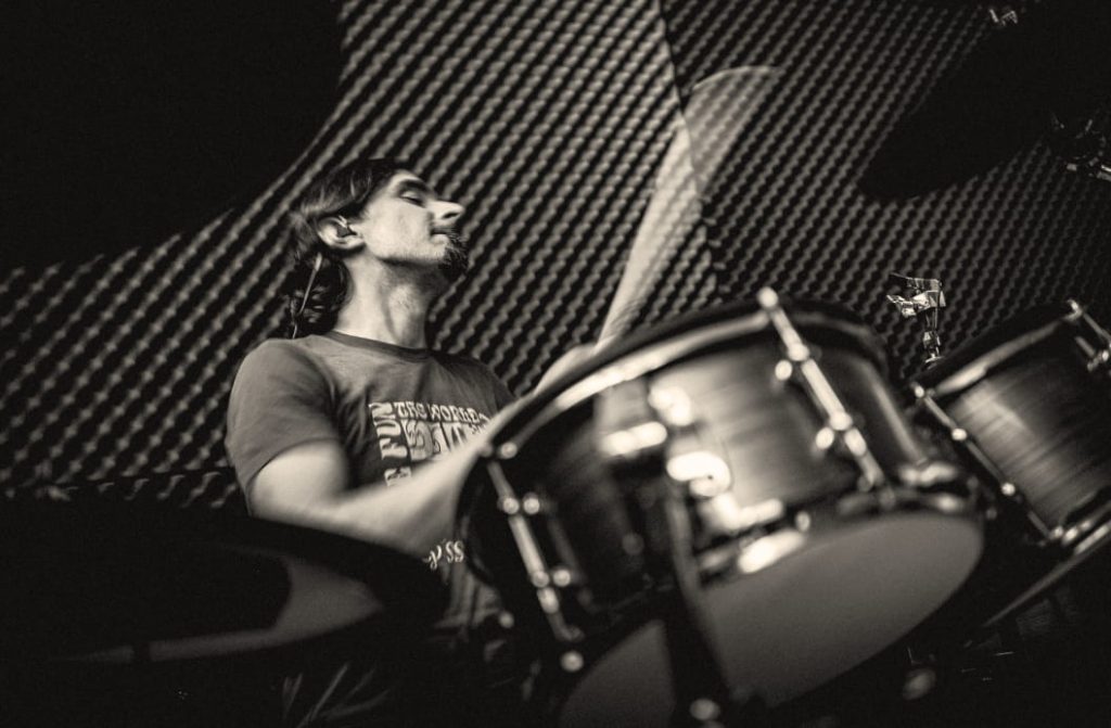Black and white photo of drummer with eyes closed