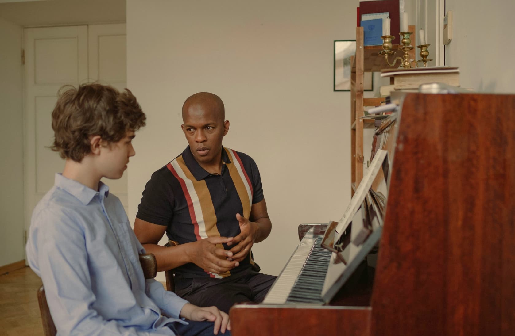 Piano lessons with a man teaching piano to a boy