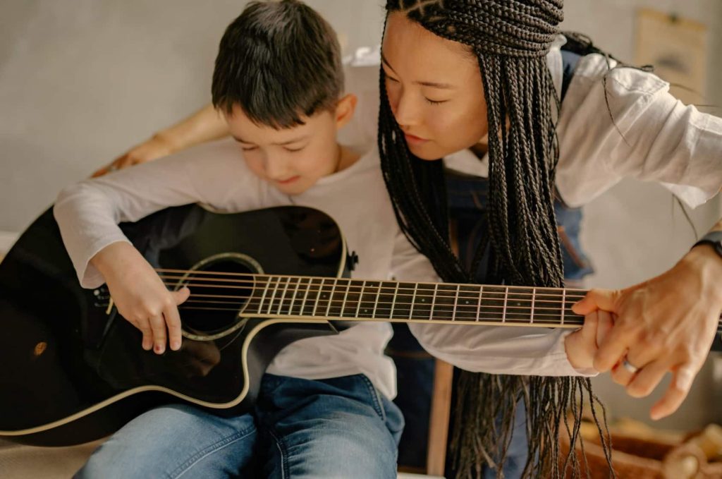 Boy in guitar lessons with guitar teacher