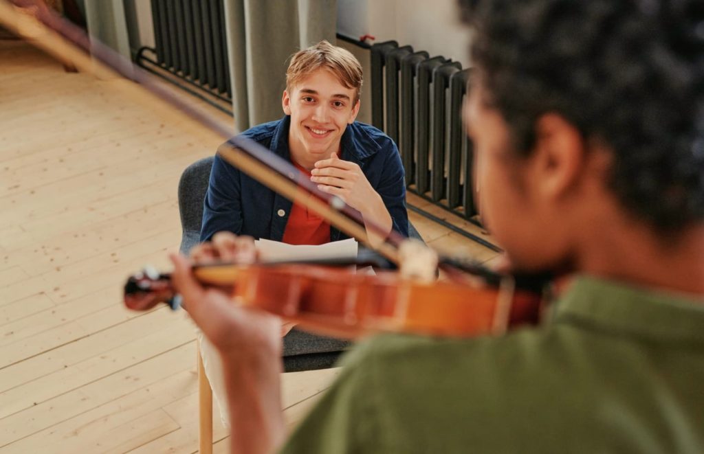 Violin teacher in violin lessons with student