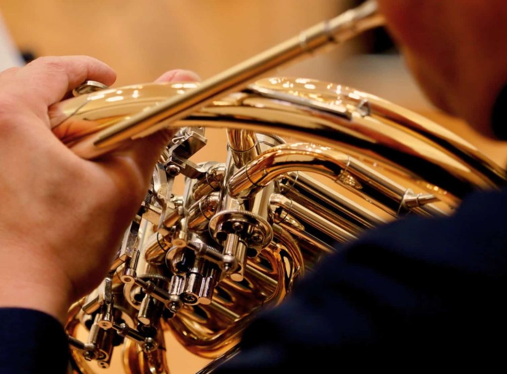French horn player up close in orchestra