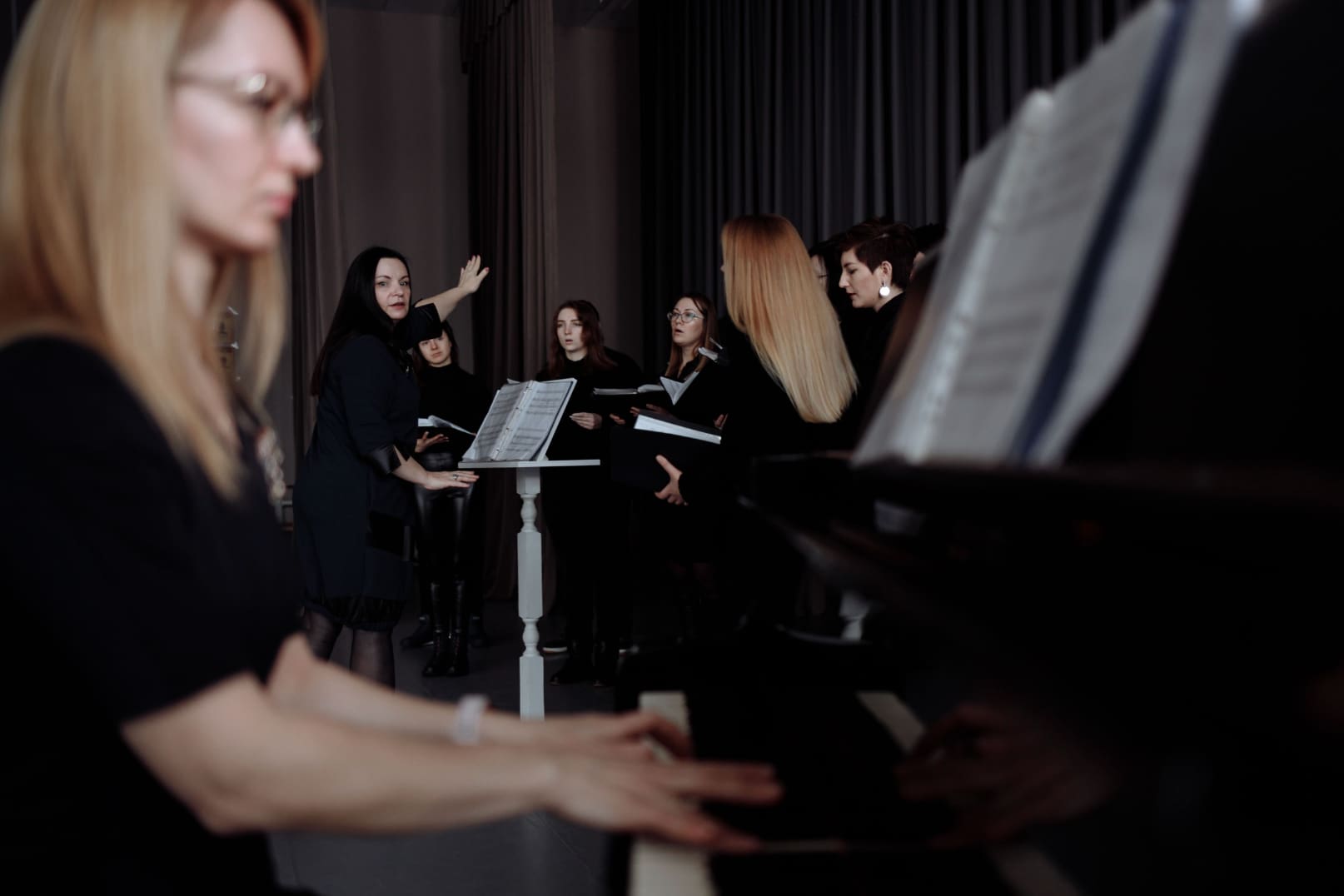 lady accompanying piano for a choir with a conductor