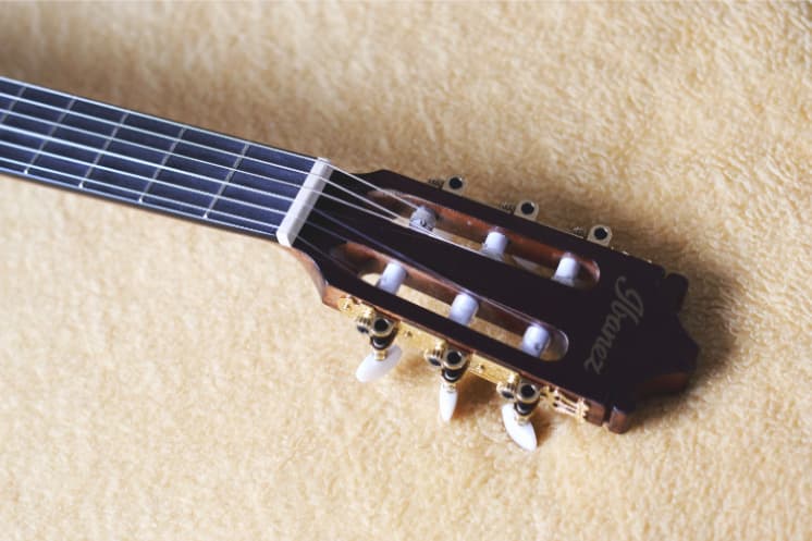 Close up view of the headstock and tuning pegs of an acoustic guitar