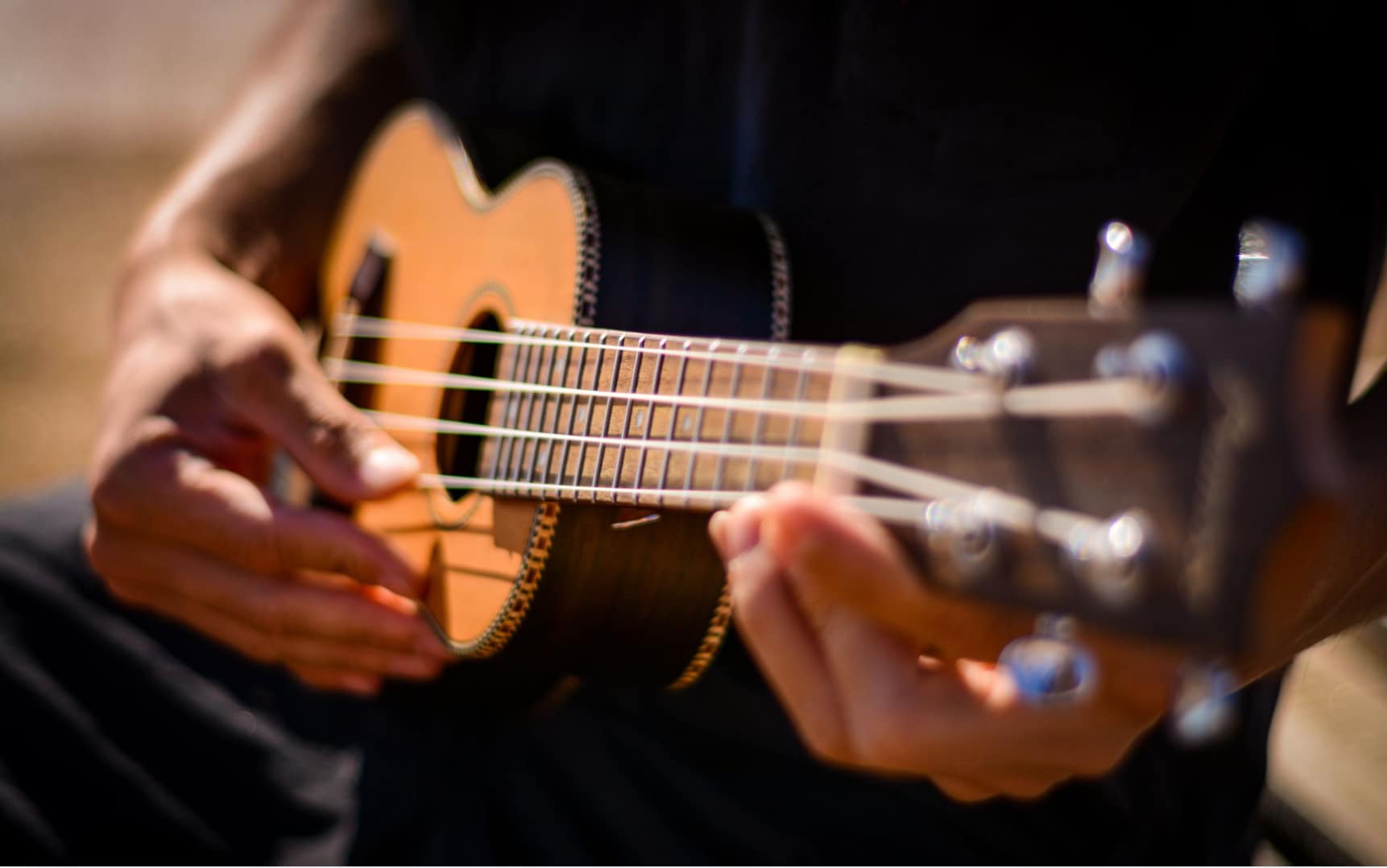 Close-up of a ukulele being played by a beginner musician
