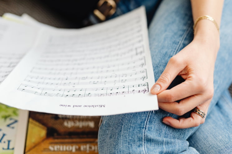 A beginner learning how to read sheet music from a printed page