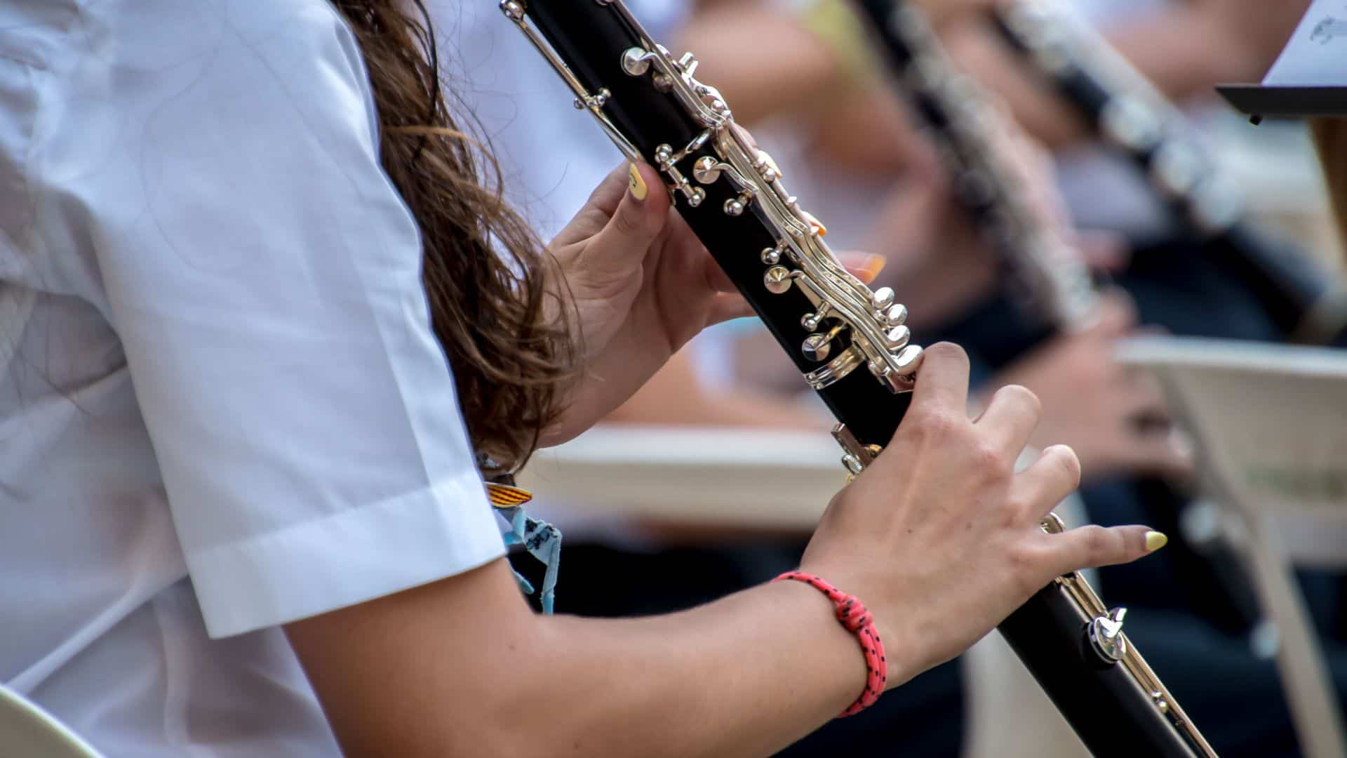 Close-up of a musician playing a clarinet during an outdoor performance. Focus on the instrument.