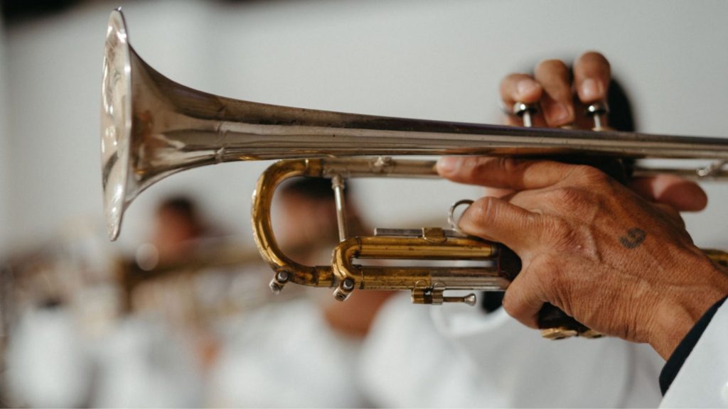 A musician elegantly playing a trumpet in a band, capturing the art of music performance.
