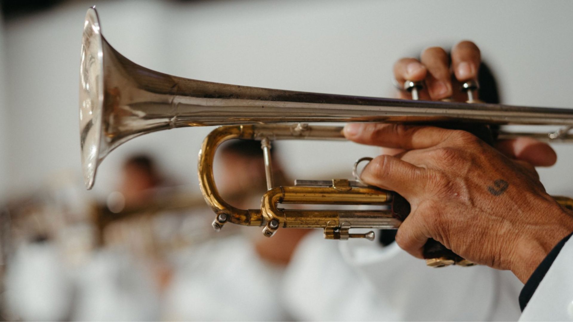 A musician elegantly playing a trumpet in a band, capturing the art of music performance.