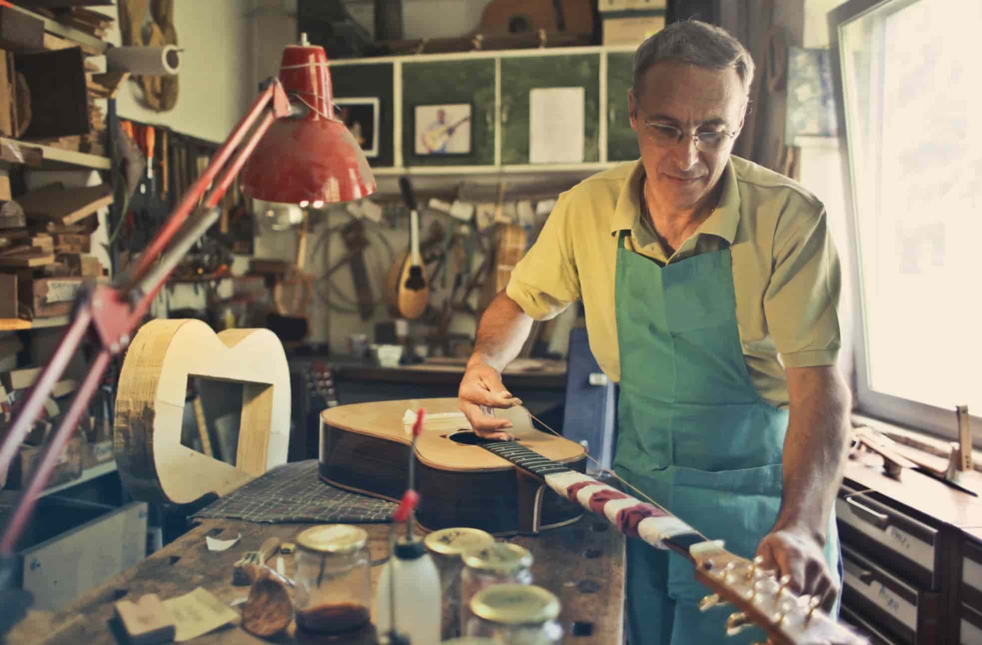 Man in workshop working on guitar