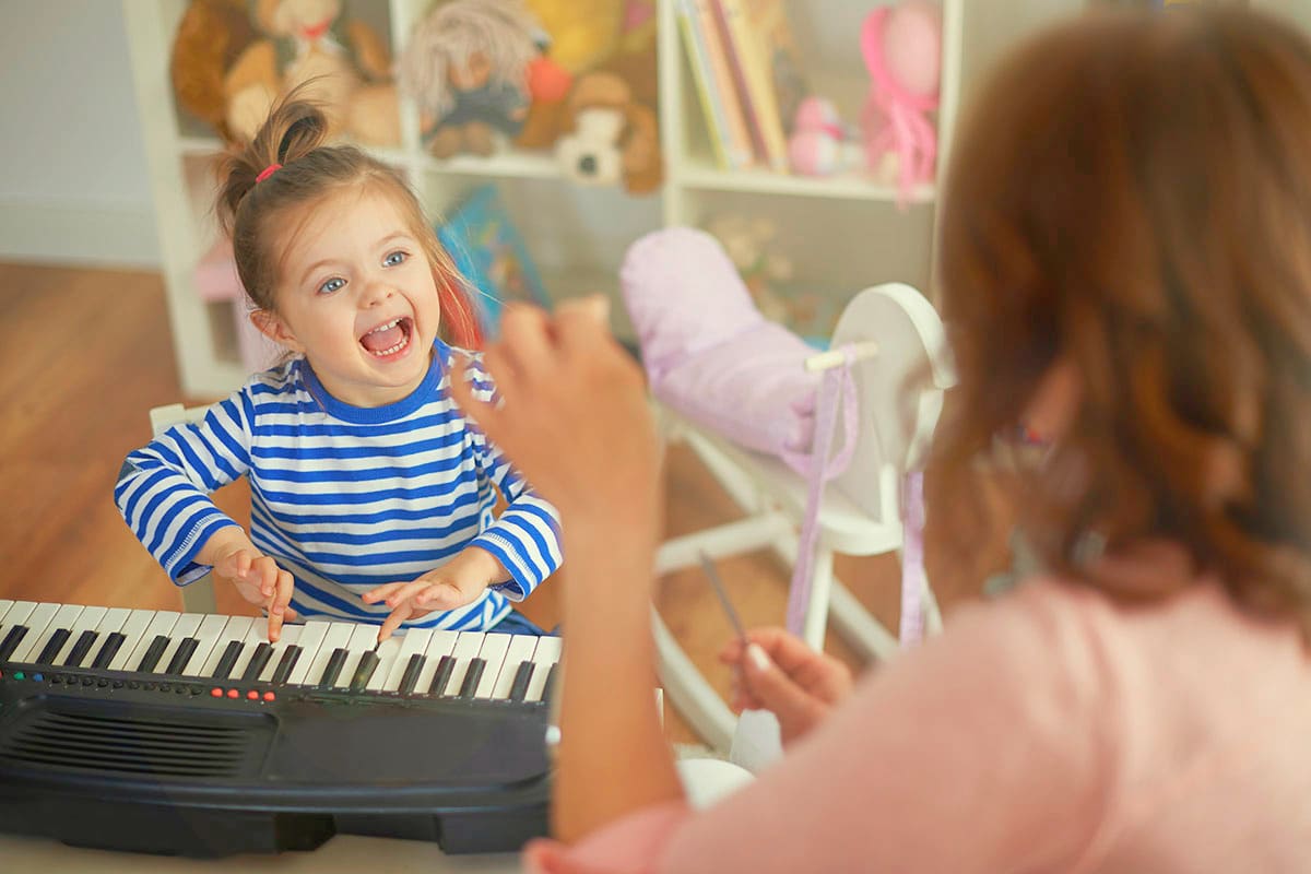 Young child learning the cello with a music teacher during a one-on-one lesson